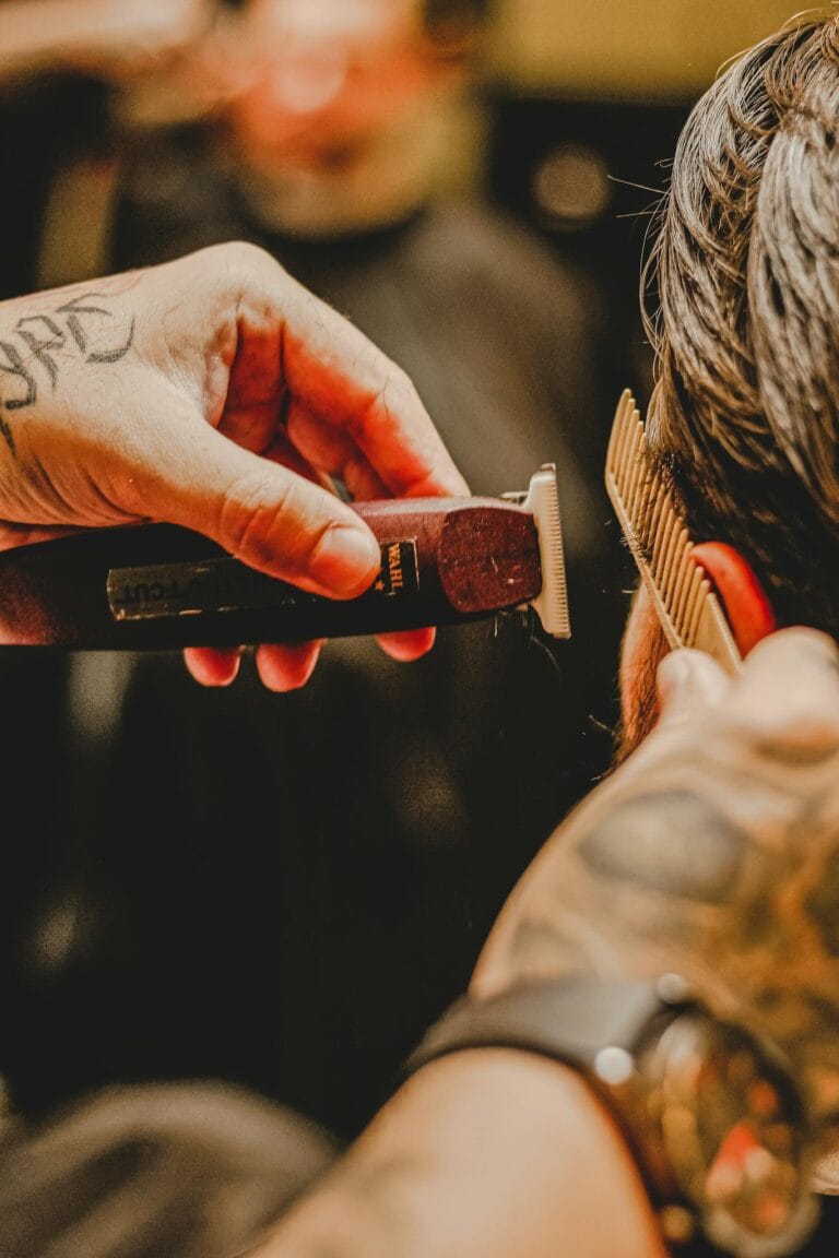 Top 3 Battle of the Wahl Cordless Clippers: Wahl Magic Clip, Wahl Legend, and Wahl Senior Review 10 crop faceless tattooed barber combing hair of