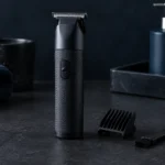 Cordless T-blade trimmer with a comb and brush on dark slate