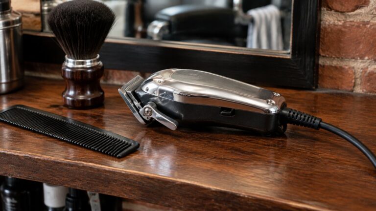 Oster Classic 76: What the Corded Clipper Offers and Who It Suits 1 Heavy-duty corded barber clipper on a shelf beside a comb and brush